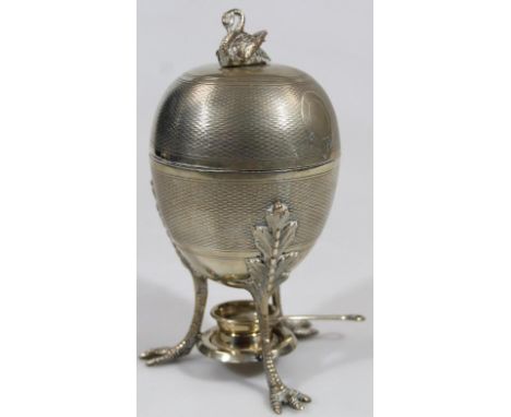 An early 20thC silver plated egg warmer, the egg shaped body on triple claw supports headed by acanthus leaves, partially eng