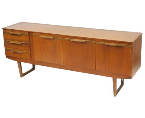 A mid century teak sideboard, with a drop down drinks cabinet flanked by three drawers to the left and a pair of cupboard doo