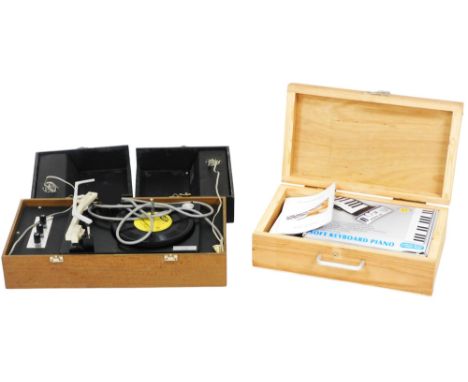 A soft keyboard piano, boxed with instructions, and outer cased, together with a Pye record player, model 1021, serial number