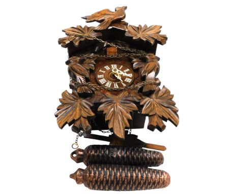 A Black Forest cuckoo clock, the dial bearing Roman numerals, with two train movement, case carved with birds and leaves, wit