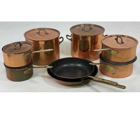 A quantity of contemporary copper coated pans with non-stick surfaces