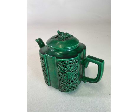 A Chinese green glazed reticulated teapot with leaf and bud moulded finial, rounded rectangular main body with four pierced p