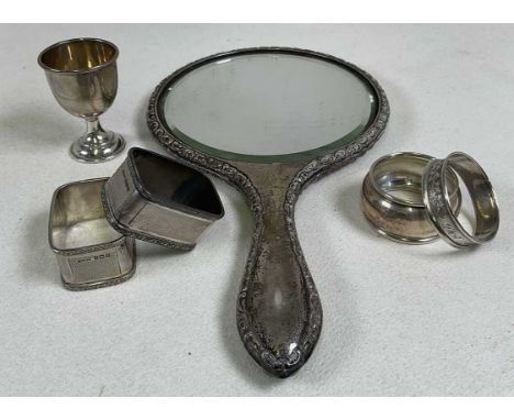 A George V hallmarked silver backed hand mirror, Chester 1922, four silver napkin rings and a silver egg cup, combined weigha