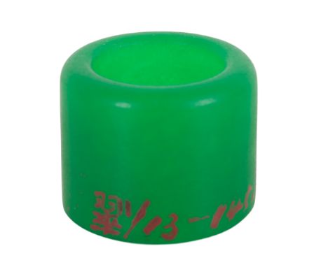A CHINESE GREEN JADE ARCHER'S RINGprobably Qing dynasty, inscribed in red to one side, 2.7cm high x 3.3cm diameter, in a turn