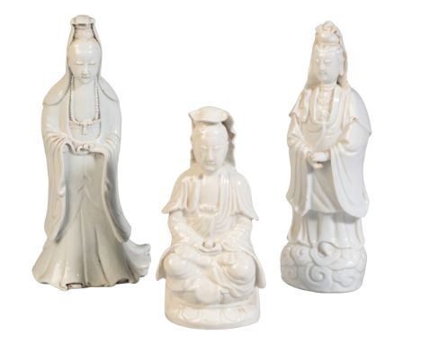 THREE CHINESE BLANC DE CHINE GUANYIN FIGURES 19th century or later, two standing and one seated on lotus base, the tallest 27