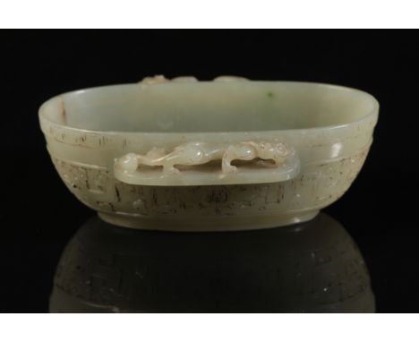 A CHINESE CELADON JADE OVAL BOWL with a chilong climbing along the projecting side handles, the body with archaistic decorati
