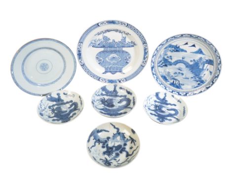 SEVEN CHINESE BLUE AND WHITE VESSELS 19th century, four shallow dishes decorated with dragons chasing flaming pearls, the lar