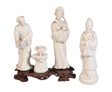 A GROUP OF THREE CHINESE BLANC DE CHINE CERAMICS MOUNTED ON A WOODEN STAND 19th century or later, composed of two courtly lad