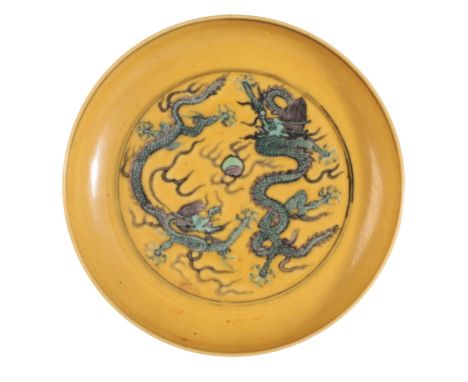 A CHINESE YELLOW-GROUND SAUCERbearing a six character Jiajing seal mark to the base, decorated to the interior with dragons c