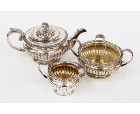 A George III Scottish regency sterling silver three piece tea service, with lobed decoration to the lower half and acanthus l