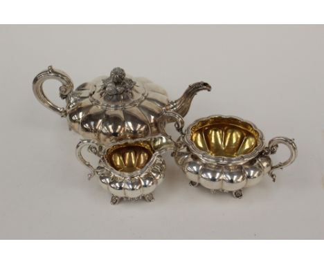 A George IV silver melon form three piece tea service, comprising teapot, sugar basin and cream jug, the teapot with cast flo