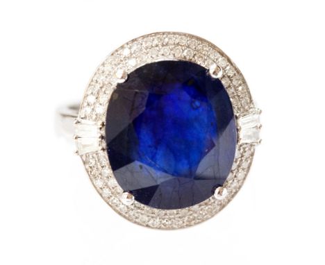 A 14k white gold and diamond ring set with an oval cut blue sapphire of approximately 10.60ct, the diamonds approximately 1ct