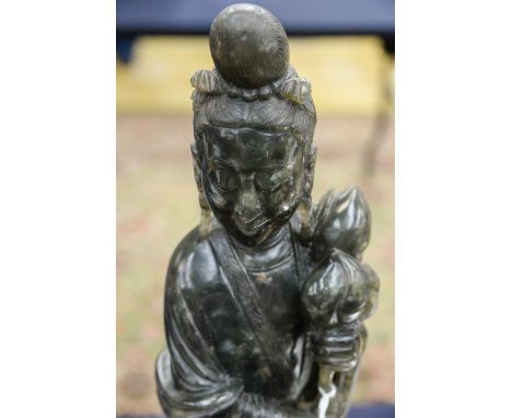 A Chinese carved jade figure of a woman, spinache green colour, on wooden stand, 47cm high