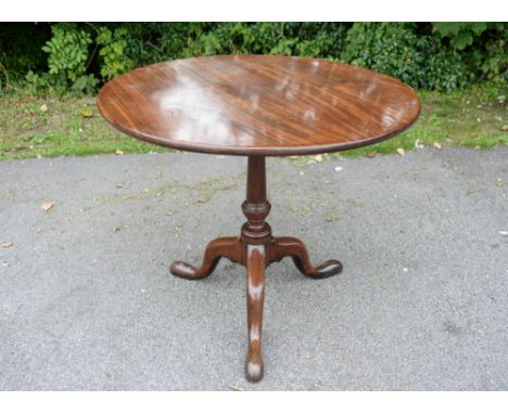 A mid 18th century mahogany tripod table, circa 1760, the circular single plank top raised on a baluster and ring turned colu