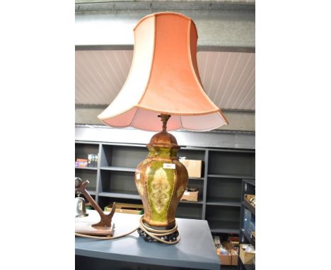 A ceramic lamp of baluster form having orange shade, decorated with stylised floral patterns on a glaze ground, h72cm