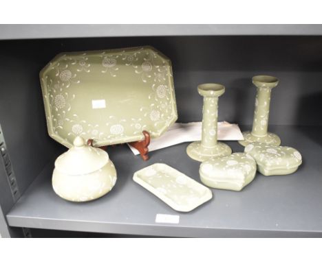 A pair of Harry Barnard (1862-1933) Wedgwood candlesticks decorated with floral patterns on a green ground, signed to base, h