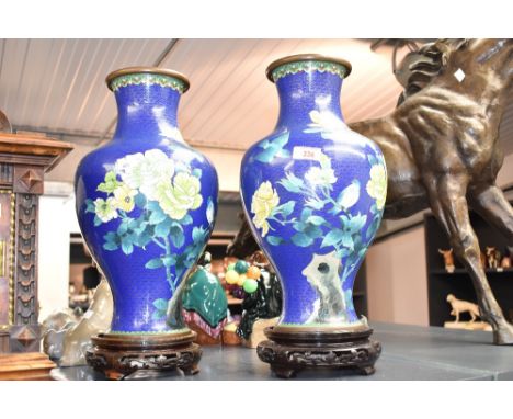A pair of large and decorative Chinese cloisonné enamel baluster vases, decorated with blossoms and birds against a blue grou