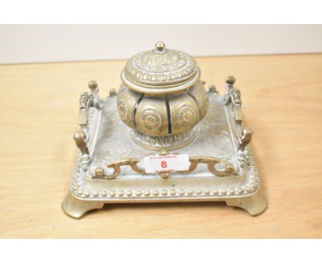 A 19th century brass inkwell with central lidded ink holder, decorated with ornate floral patterns, w17cm