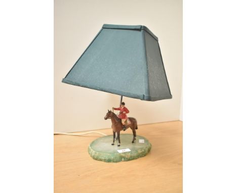 A vintage lamp, having a stained white stone green old painted metal huntsman on horse, 36cm