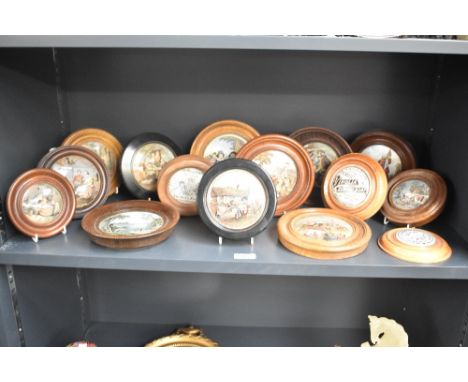 Fifteen wooden mounted ceramic Pratt ware, pot lids, having decorative scenes and three with advertising graphics.
Condition 