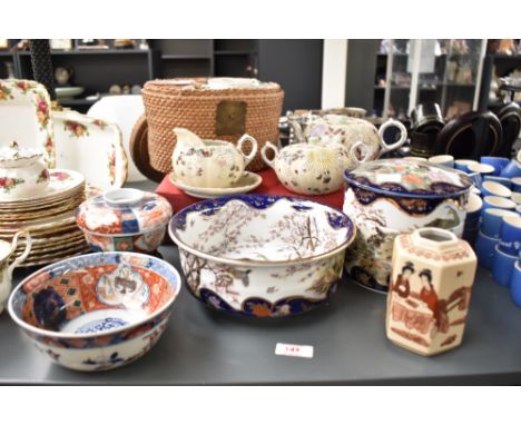 A Chinese wicker tea cased set having ceramic tea pot and bowl, decorated with gilt edging and landscape scenes, sold togethe