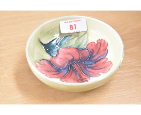 A Moorcroft pottery Hibiscus pattern footed trinket dish, having a yellow-green ground, 11.5cm diameter