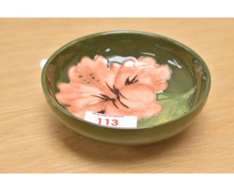 A Moorcroft pottery footed Hibiscus pattern trinket dish, having green glaze, impressed mark to base, h4cm