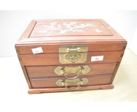 A vintage Chinese rosewood and brass jewellery box, having mother-of-pearl inlay to the lid and decorative brass handles, red