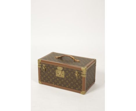 LOUIS VUITTON: A LEATHER COVERED TRAVELLING JEWELLERY OR MAKE-UP CASE of trunk form with bound edges, brass corners and centr
