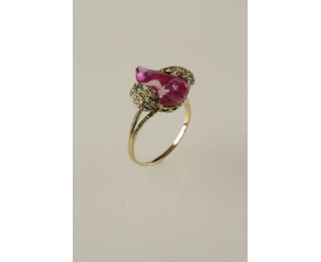 A CONTINENTAL RUBY AND DIAMOND RING designed as a bird with a polished cabochon ruby body and diamond-set wings, on diamond-s