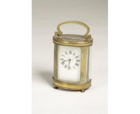 A FRENCH BRASS CASED CARRIAGE CLOCK, the white enamel dial with Roman numerals, in an oval case with ball feet and swing hand