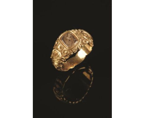 THE NELSON-HALLOWELL RING: A YELLOW GOLD MEMORIAL RING "carved" with scrolling foliage, rocaille-work and flowers, the glazed