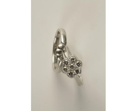 A DIAMOND FLOWERHEAD RING set in platinum with open-work shoulders, and a platinum wedding band shaped to fit the flowerhead 