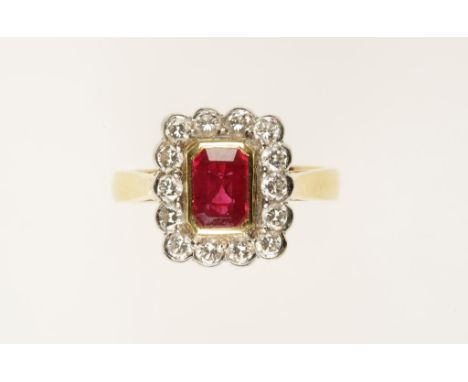 A "RUBY" AND DIAMOND DRESS RING, the emerald-cut "ruby" in a yellow gold collet setting, surrounded by 14 rub-over set diamon