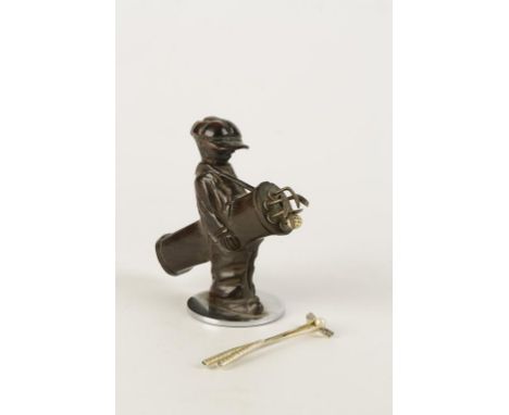 A NOVELTY CARVED WOOD TOOTHPICK HOLDER in the form of a caddy holding a bag of golf clubs, 10.5cm high, and a Trifari brooch 
