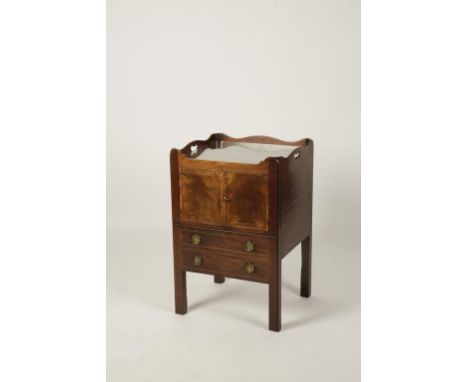 A GEORGE III MAHOGANY COMMODE, the rectangular top with wavey border with pierced hand holds above twin cupboards and drawer 