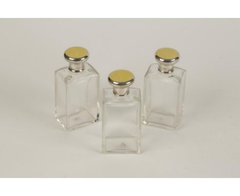 A SET OF THREE DRESSING TABLE BOTTLES with silver and yellow guilloche enamel tops, London 1940, 5" high