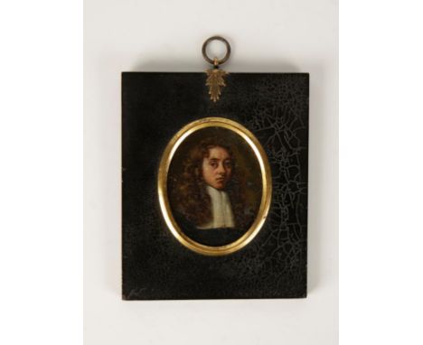 AN OVAL PAINTED PAINTED MINIATURE PORTRAIT ON COPPER OF A GENTLEMAN with long brown hair, wearing a white collar, in black eb