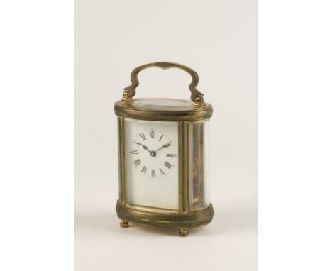 A FRENCH BRASS CASE CARRIAGE CLOCK, the white enamel dial with Roman numerals, in an oval case with swing handle, 6" high inc