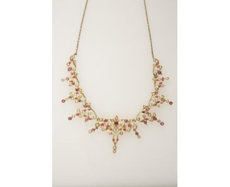 AN INDIAN RUBY AND PEARL NECKLACE, each flower and foliage with attached drops, set on unmarked yellow metal, attached to a f
