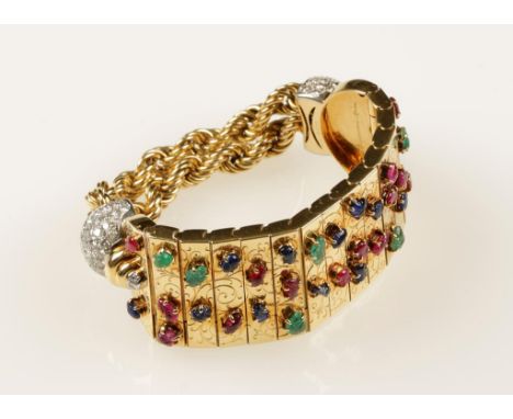 A BOUCHERON EMERALD, SAPPHIRE, RUBY AND DIAMOND BRACELET set on an engraved yellow gold articulated panel with numerous caboc