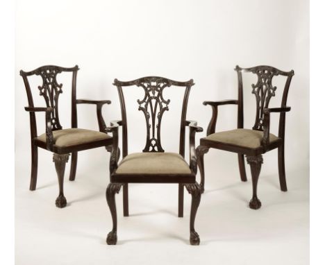 A SET OF SIX "CHIPPENDALE" STYLE ARMCHAIRS with carved and pierced splats and toprails, the scrolling arms with leaf-carved s