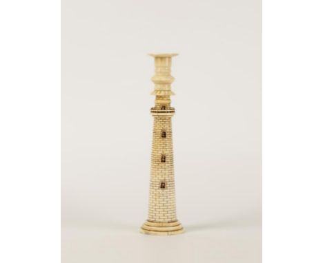 A CANDLESTICK in the form of a lighthouse with a turned sconce resting on a tapering lighthouse with six pierced windows and 