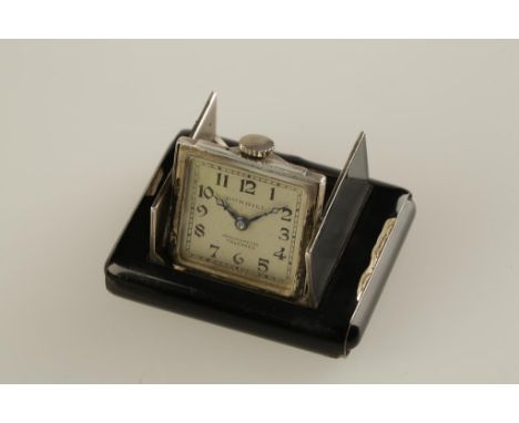 DUNHILL: A LADIES BLACK ENAMEL PURSE WATCH, the push open case revealing a square dial with Arabic numerals, inscribed "Dunhi