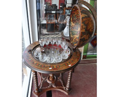 A 20th century drinks cabinet in the form of a terrestrial globe, the hinged top section opening to reveal an interior fitted