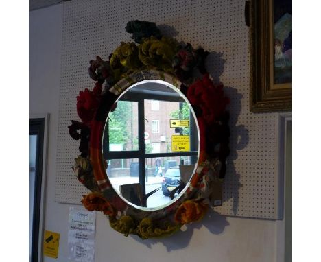 A 'Squint' overmantle mirror, with patch work upholstered frame, with bevelled plate, 111 x 100cm 