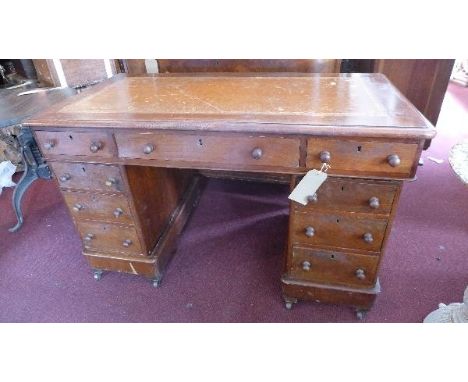 A Victorian mahogany pedestal desk, with brown leather skiver, above nine drawers, raised on castors 
