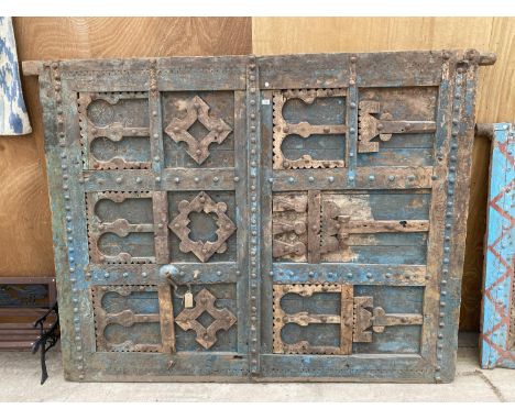 A HEAVILY CARVED AND DECORATIVE MOROCCAN DOOR WITH METAL BANDING AND STUD WORK, TO INCLUDE METAL DOOR KNOCKER (W:70" H:87.5")