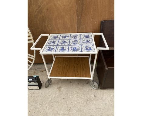 A VINTAGE RETRO TEA TROLLEY DECORATED WITH DELFT TILE EFFECT AND REVERSIBLE TIERS 
