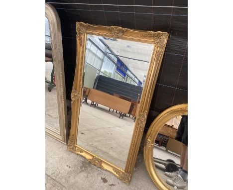 A DECORATIVE GILT FRAMED WALL MIRROR 